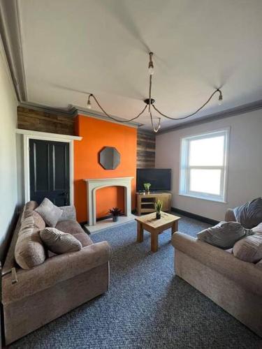 ein Wohnzimmer mit 2 Sofas und einem Kamin in der Unterkunft Stylish 5 bedroom /7bed apartment in Seacombe