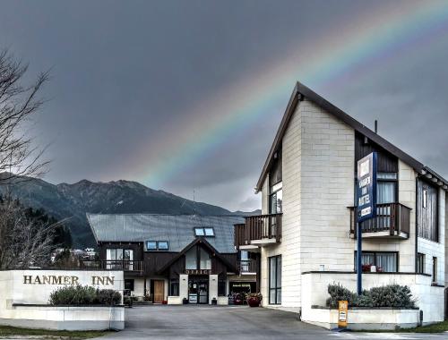 a building with a mountain in the background at ASURE Hanmer Inn Motel Hanmer Springs in Hanmer Springs