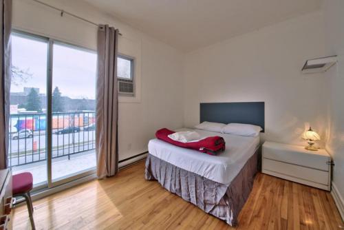 a bedroom with a bed and a large window at Hotel Mini Inc in Montréal