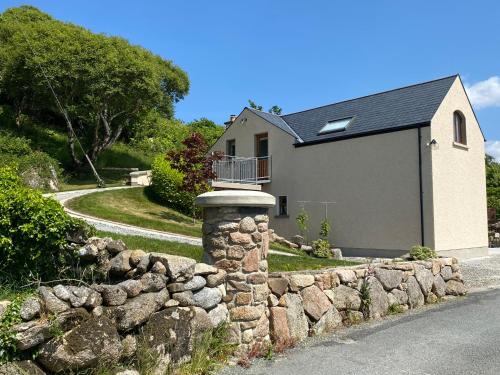 un muro de contención de piedra frente a una casa en Hazel View Apartment, en Bunbeg
