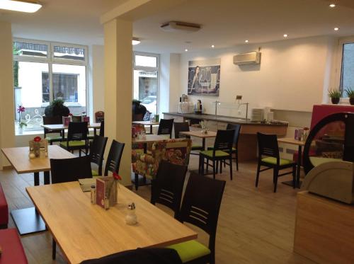 a restaurant with tables and chairs and a counter at Pension Altstadt Garni in Bad Windsheim