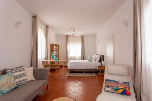 a living room with a couch and a bed at Casa da praia in Carrapateira