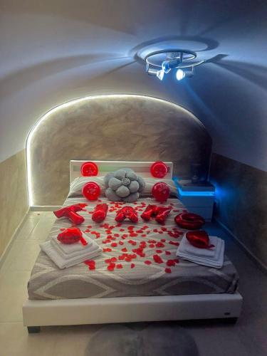 una cama con rosas rojas en una habitación en Valentine’s Suite, en Catania