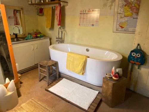 a bathroom with a large white bath tub and a sink at La Chevalière Sauvage in Tourves