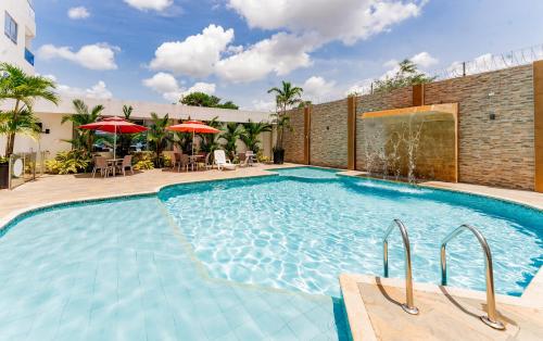 a large swimming pool with chairs and umbrellas at Hotel Miraval in Montería