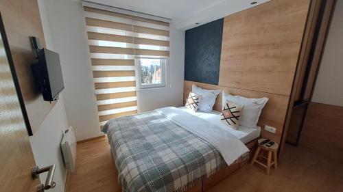 a bedroom with a bed and a flat screen tv at Vila Jahor Apartmani JET SET Lux 4,5,6 in Jahorina