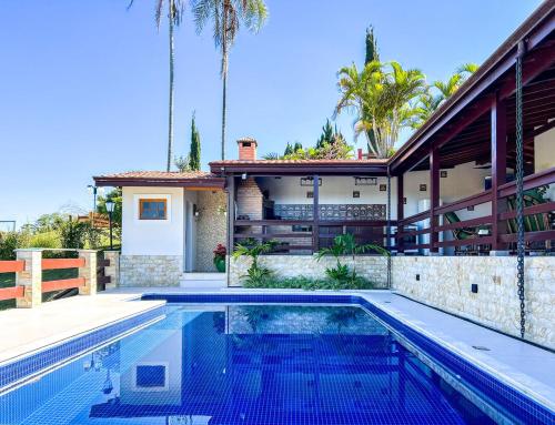 a swimming pool in front of a house at Casa de campo c churrasqueira e Wi-Fi Itatiba SP in Itatiba