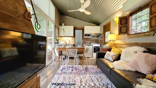 a living room with a couch and a kitchen at Rusty's Hideaway - Adorable tiny house on a beautiful farm in Moorland