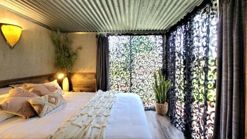 Un dormitorio con una cama con una ventana grande. en Rusty's Hideaway - Adorable tiny house on a beautiful farm, en Moorland