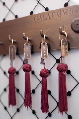 a clock with red tassels hanging on a wall at GALATA M84 in Istanbul