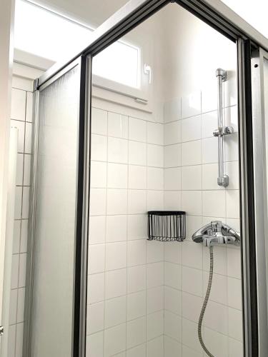 une salle de bain avec une douche avec une porte vitrée dans l'établissement La Petite Rémoise - Hyper Centre, à Reims