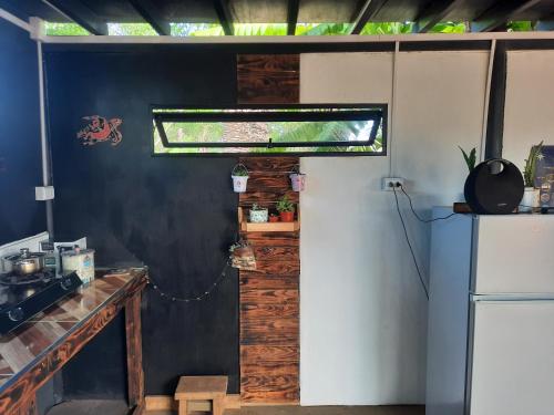 a kitchen with a refrigerator and a window in a room at Moehiva Camping Rapa Nui in Hanga Roa