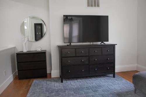 a bedroom with a dresser with a flat screen tv on it at Your Cozy and Relaxing Retreat in Woburn
