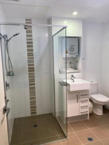 a bathroom with a shower and a sink and a toilet at Quiet apartment adjacent Parliament House in Kingston 