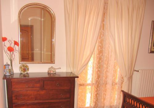 a bedroom with a dresser and a mirror at La Casa Dei Boschi in San Marino