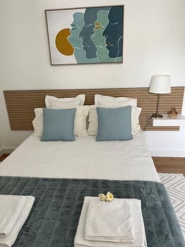 ein Schlafzimmer mit einem großen Bett mit blauen Kissen in der Unterkunft HOUSE NEXT TO THE THEATER in Évora