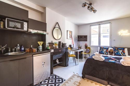 Il comprend une chambre avec un lit et une cuisine avec un évier. dans l'établissement ExploreReims - Studio intergalactique chic proche gare/centre, à Reims
