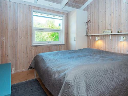 a bedroom with a bed and a window at Four-Bedroom Holiday home in Ebeltoft 12 in Ebeltoft