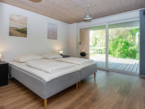a bedroom with a large bed and a sliding glass door at Holiday home Galten in Galten