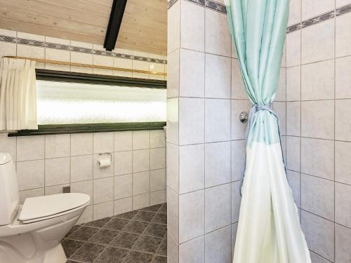 a bathroom with a toilet and a shower curtain at 6 person holiday home in Væggerløse-By Traum in Marielyst