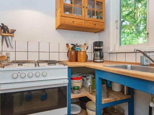 a kitchen with a stove and a sink at 4 person holiday home in Bryrup in Bryrup