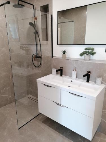 a bathroom with a white sink and a shower at Apartman Vesa in Dolac