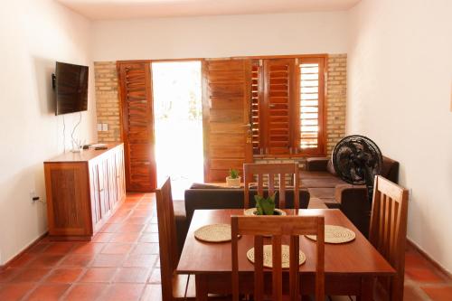 a living room with a dining room table and chairs at Apartamentos da Jangada in Canoa Quebrada