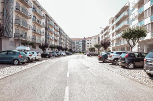an empty street with parked cars in a city at Pilgrim Home in Fátima