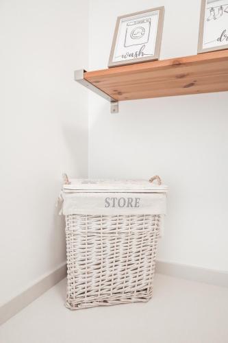 a white wicker basket sitting next to a shelf at Pilgrim Home in Fátima