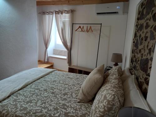 a bedroom with a bed and a mirror and a window at Amieira do Tejo guest house in Barca da Amieira