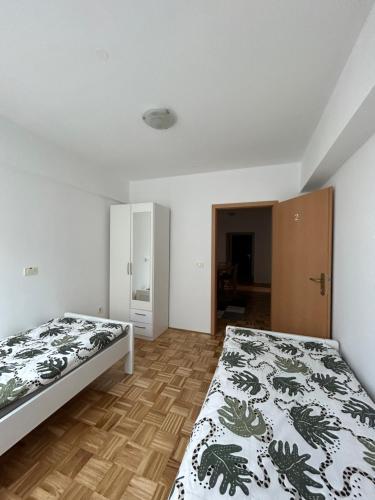 a bedroom with two beds and a wooden floor at Apartma Lunca 2 in Ljubljana