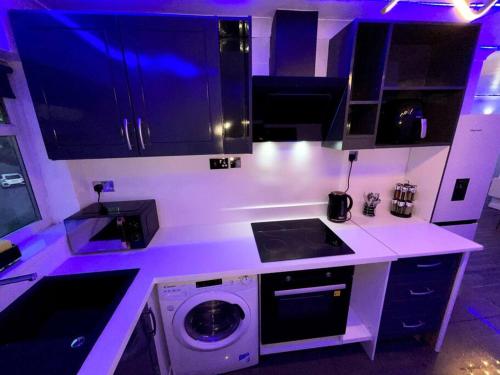 a kitchen with a sink and a washing machine at Chic 2 Bedroom Flat in Trimley Heath