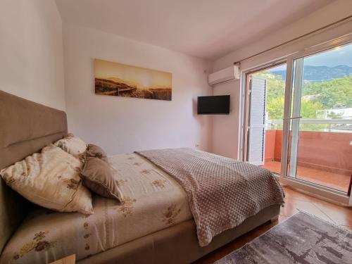 a bedroom with a bed and a large window at Dom M Apartments in Budva