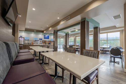 a dining room with tables and chairs and windows at Holiday Inn Express Golden-Kicking Horse by IHG in Golden
