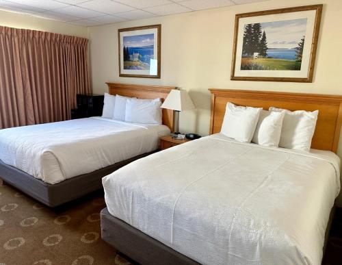 a hotel room with two beds with white sheets at Safari Hotel Boardwalk in Ocean City