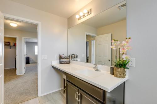 a bathroom with a sink and a mirror at Spacious Avondale Home with Patio and Pool Access! in Avondale