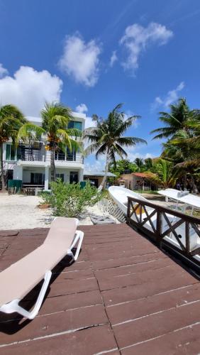 a bench on the beach near a building at On The Beach - Seaside Sunrise Haven 3 Bedrooms SEA VIEW in Cancún