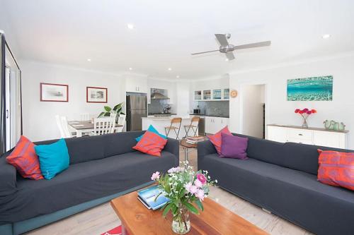 a living room with a blue couch with colorful pillows at LUXURY TOWNHOUSE! Walking distance to everything! in Yamba