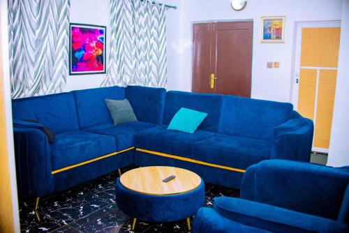 a blue couch and two blue chairs in a living room at Homey 2-Bed-Apt 24HRS POWER & Unlimited Internet Access in Lagos