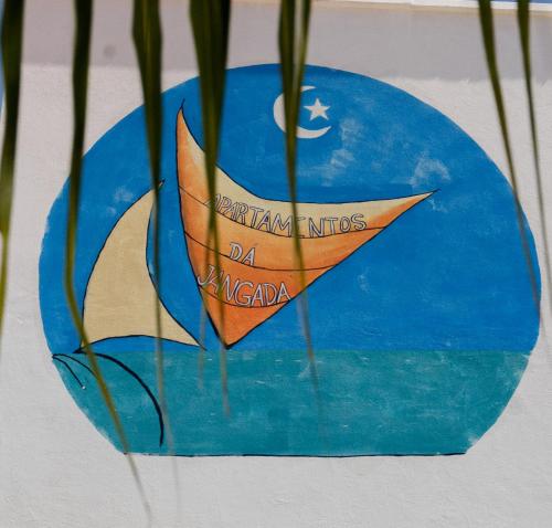 a painting of a paper boat on a blue plate at Apartamentos da Jangada in Canoa Quebrada