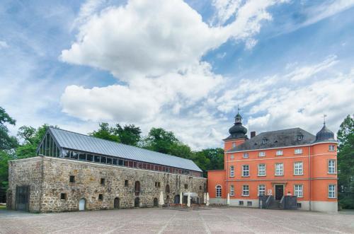 a large brick building next to a red building at Holiday Inn Express Cologne Troisdorf by IHG in Troisdorf
