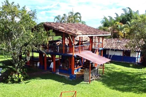 ein Haus mit einer Terrasse im Gras in der Unterkunft RanchoVista coffee ring The land of Encanto in Quimbaya