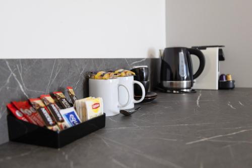 a counter with two coffee mugs and snacks on it at Bairnsdale International in Bairnsdale