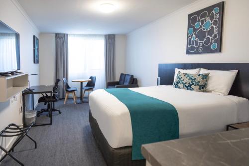 Habitación de hotel con cama, mesa y sillas en Bairnsdale International, en Bairnsdale