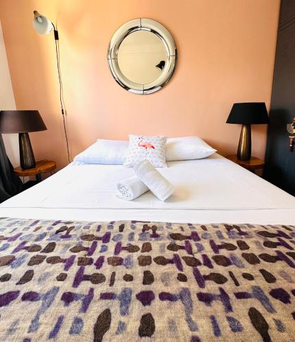 een slaapkamer met een bed met een spiegel aan de muur bij Le cocon de l’abbaye in Marseille