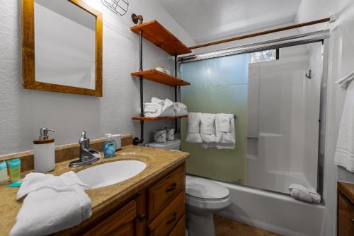a bathroom with a sink and a shower and a toilet at Shepherd's Cabin - Gambrel cabin, spacious while still being cozy and inviting! in Big Bear City