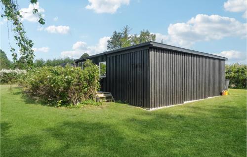 a black house in a yard with a green lawn at Cozy Home In Kalundborg With Wifi in Kalundborg