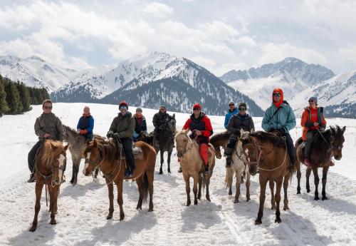 a group of people riding horses in the snow at Baitor Guesthouse in Dzhergalan