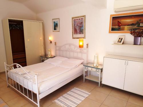 a bedroom with a white bed and two tables at Guesthouse Gradina in Lovište
