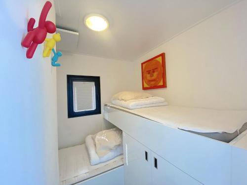 a small room with two bunk beds and a window at Woonboot Bertan in Nieuwpoort